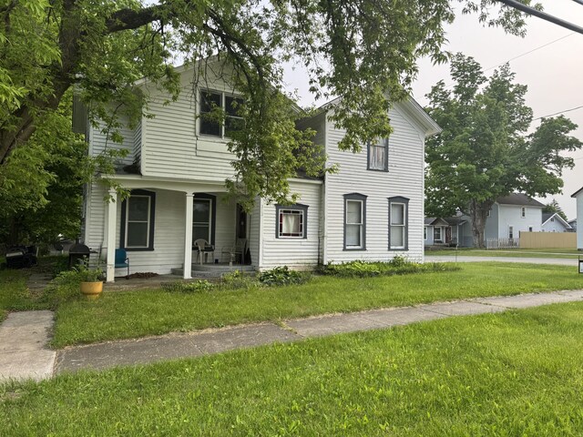 313 W 6th St, Evart, MI 49631 - view of front of property featuring a front yard and a porch