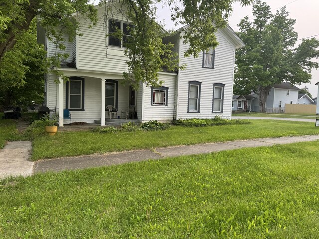 313 W 6th St, Evart, MI 49631 - view of front of home with a front lawn and a porch
