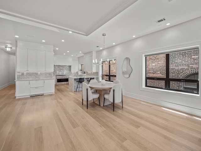 dining area with a chandelier and light wood-type flooring