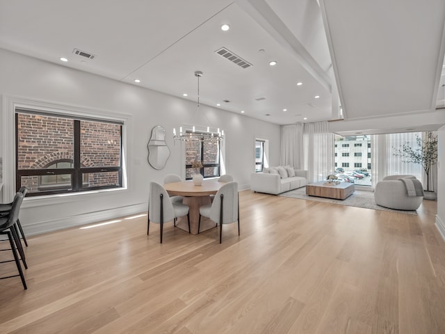 dining space featuring a wealth of natural light, a notable chandelier, and light hardwood / wood-style floors