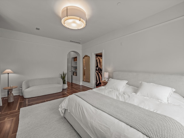 bedroom featuring a spacious closet, dark hardwood / wood-style flooring, and a closet