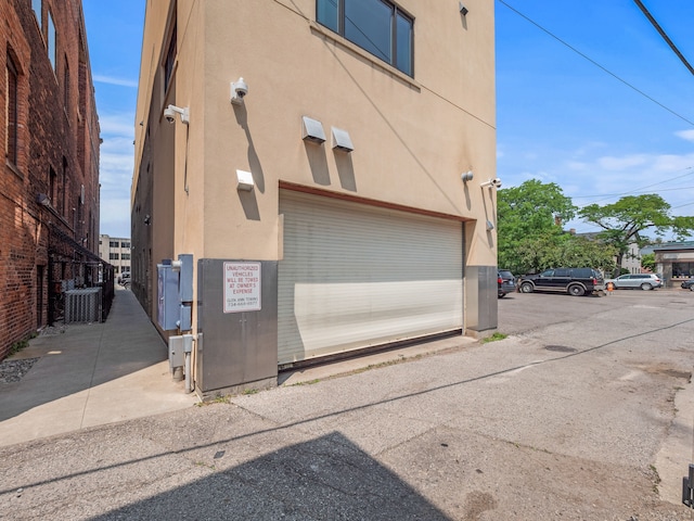 view of side of home with a garage and central AC unit