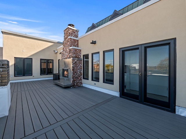 wooden deck with an outdoor fireplace