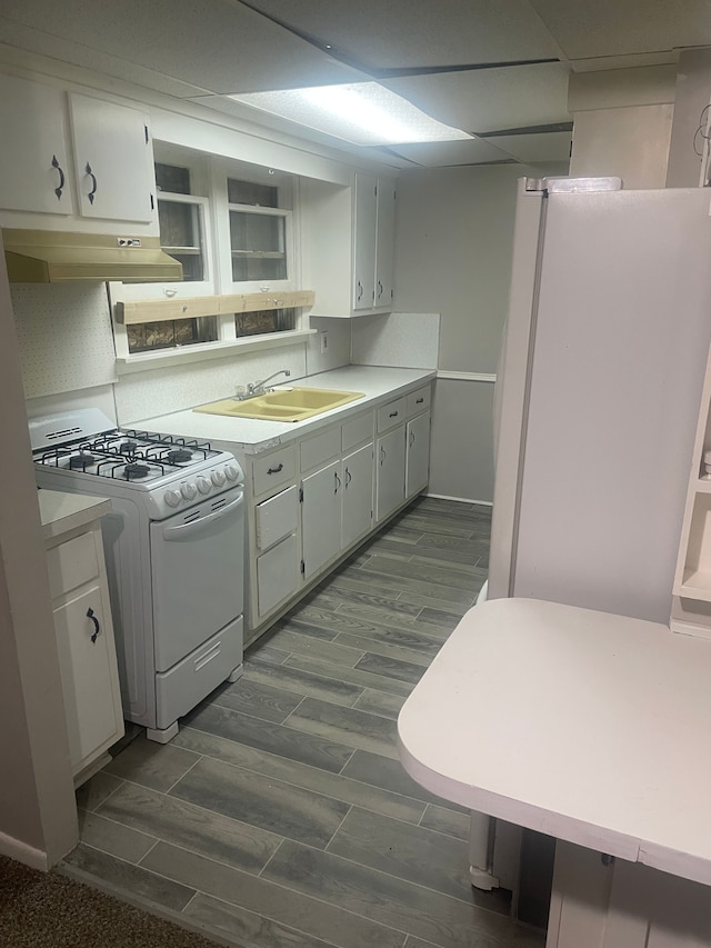 kitchen featuring sink, white cabinets, and white appliances