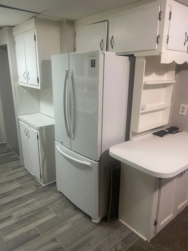 kitchen featuring white refrigerator and white cabinetry