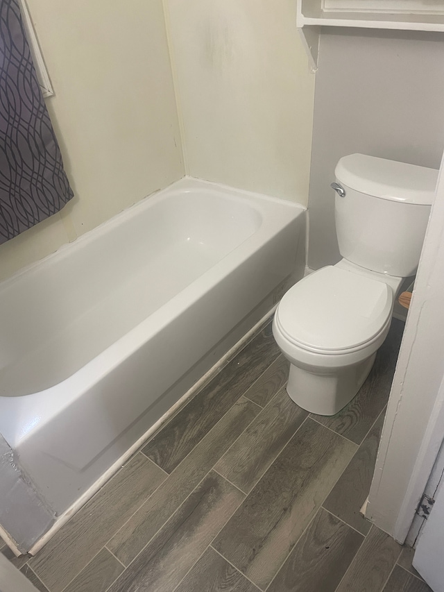 bathroom featuring a tub to relax in and toilet