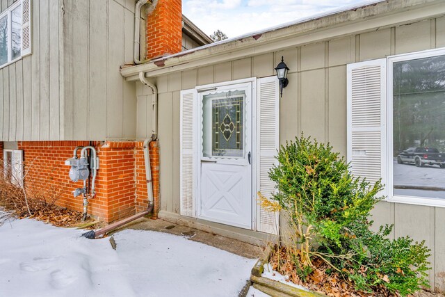 entrance to property with a chimney and board and batten siding