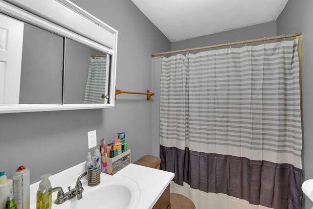 bathroom featuring curtained shower and vanity