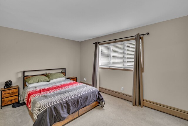 bedroom featuring baseboards, light carpet, and baseboard heating