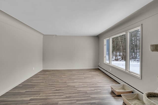 empty room with a baseboard radiator, plenty of natural light, baseboards, and wood finished floors