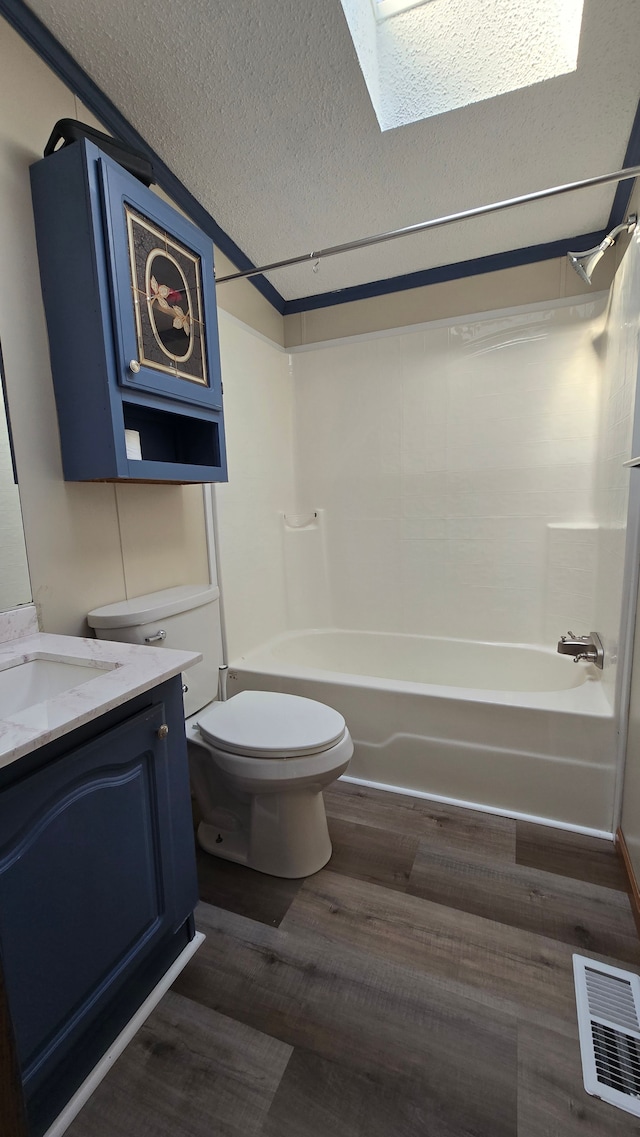 full bathroom with  shower combination, a skylight, a textured ceiling, vanity, and hardwood / wood-style flooring