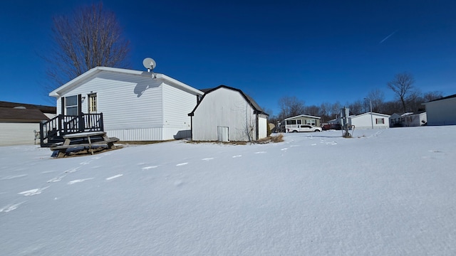 snow covered property featuring an outbuilding