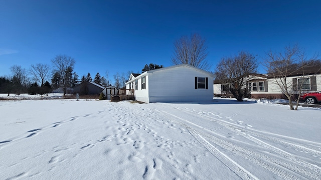 view of snowy exterior with a deck