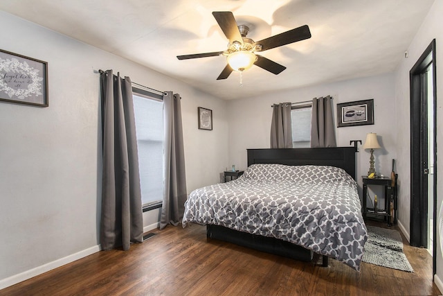 bedroom with dark hardwood / wood-style floors and ceiling fan