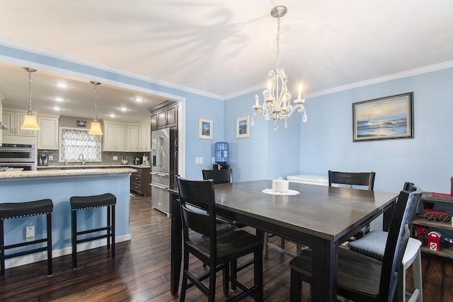 dining room featuring crown molding, dark hardwood / wood-style flooring, sink, and a notable chandelier