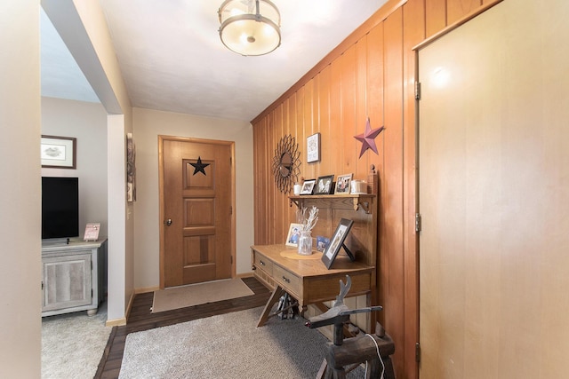 foyer entrance featuring hardwood / wood-style flooring and wood walls