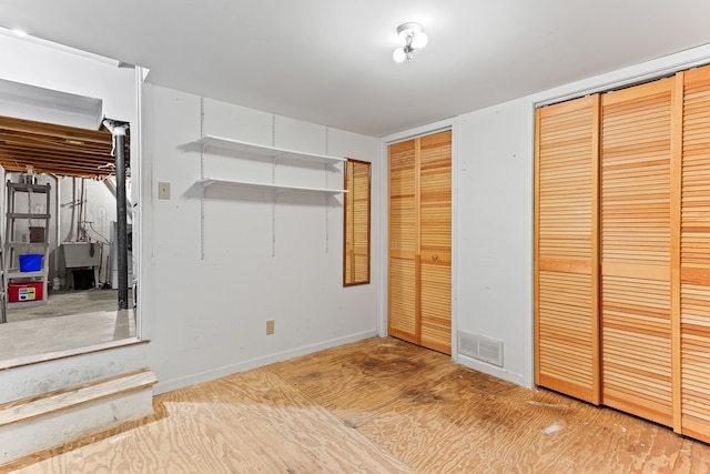 unfurnished bedroom featuring two closets and wood-type flooring