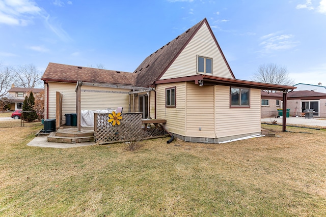 back of property featuring central AC and a lawn