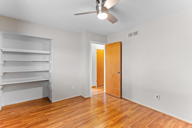 unfurnished bedroom with ceiling fan, a closet, and light wood-type flooring