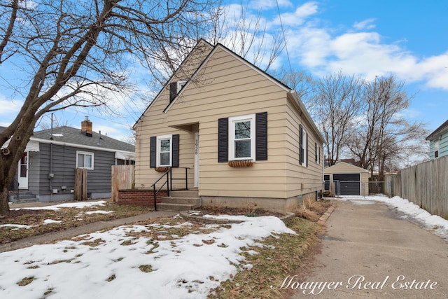 bungalow-style home featuring a garage and an outbuilding