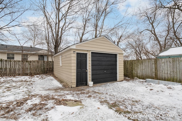 snow covered structure featuring a garage