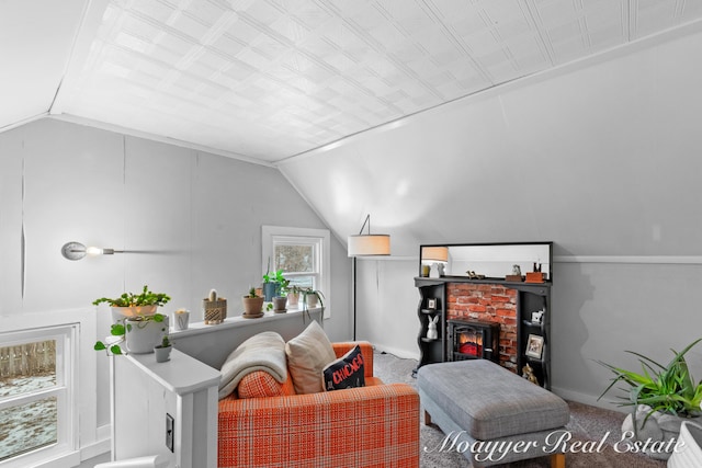 living room featuring vaulted ceiling and a brick fireplace