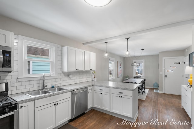 kitchen featuring sink, decorative light fixtures, kitchen peninsula, stainless steel appliances, and white cabinets