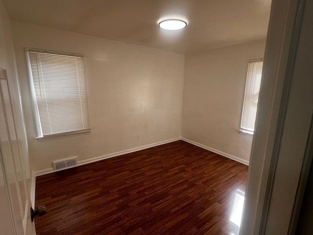 unfurnished room with dark wood-type flooring