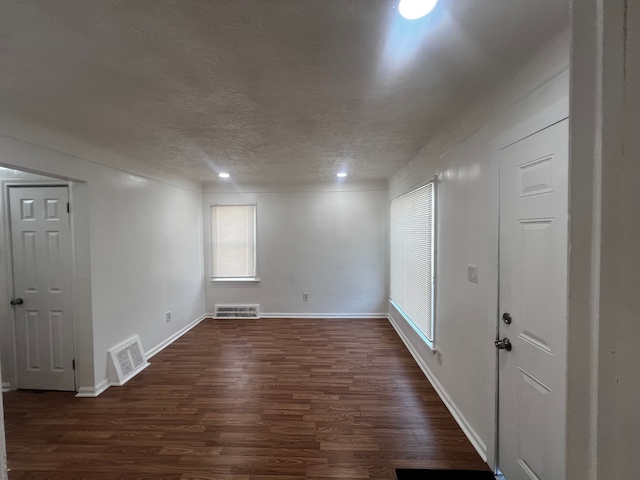 empty room featuring dark hardwood / wood-style floors and a textured ceiling