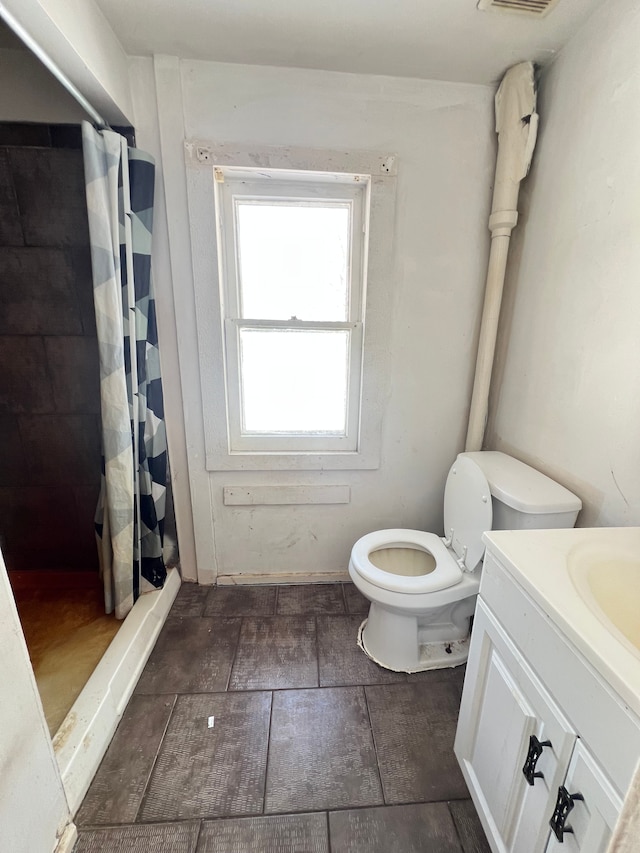 bathroom featuring toilet, vanity, and a shower with curtain