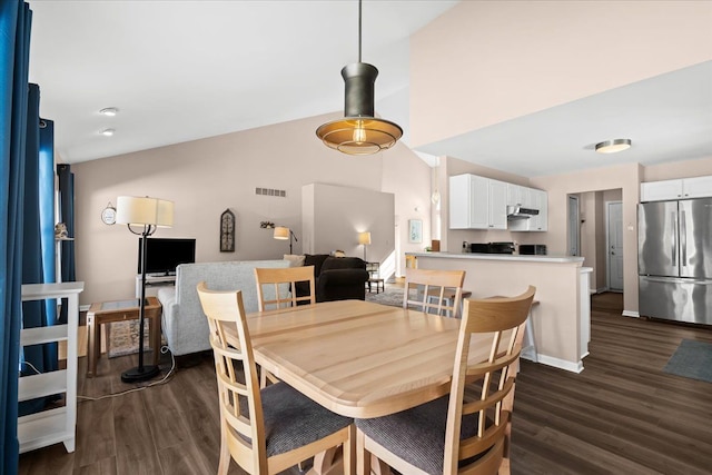 dining area with lofted ceiling and dark hardwood / wood-style flooring