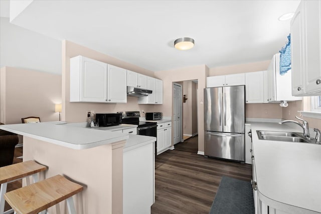 kitchen with a kitchen breakfast bar, stainless steel appliances, white cabinetry, and kitchen peninsula