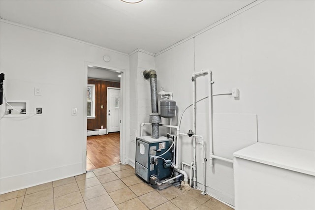 interior space with a heating unit, light tile patterned flooring, and baseboard heating