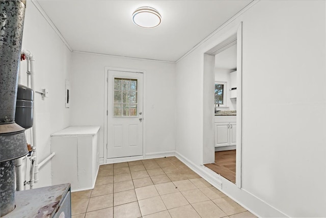 entrance foyer with baseboards, light tile patterned flooring, and crown molding