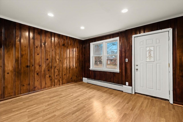 interior space with wood walls, a baseboard radiator, light wood-style flooring, and recessed lighting