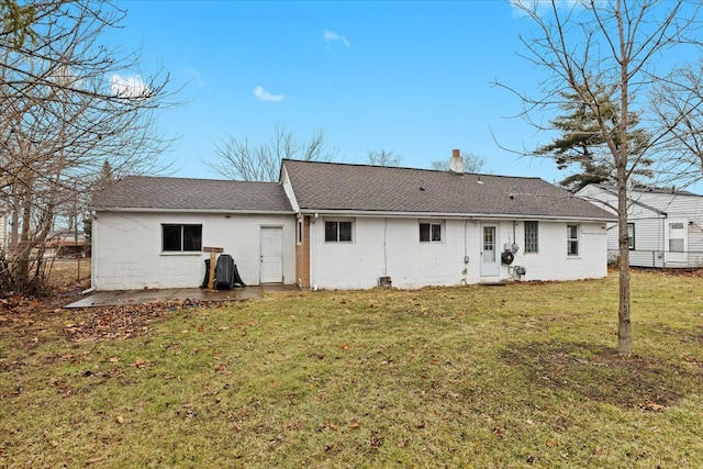 back of property featuring a patio area, roof with shingles, and a yard