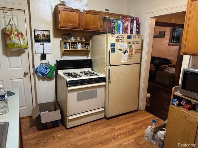 kitchen with white appliances and light wood-type flooring