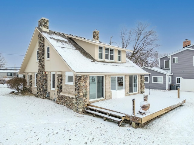 snow covered back of property with central AC