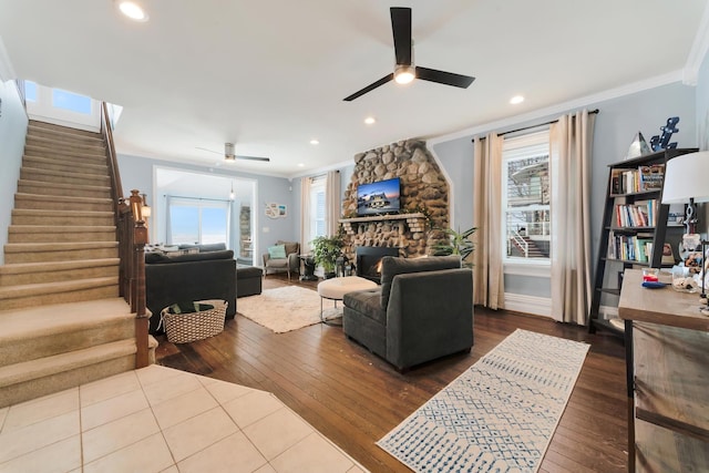 living room with ceiling fan, ornamental molding, a fireplace, and hardwood / wood-style floors