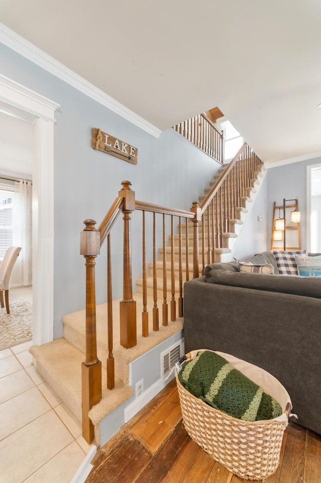 staircase with crown molding and hardwood / wood-style floors