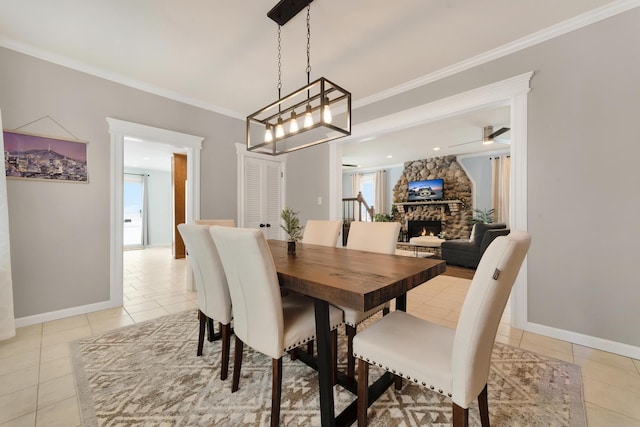 tiled dining space with a fireplace, ornamental molding, and ceiling fan