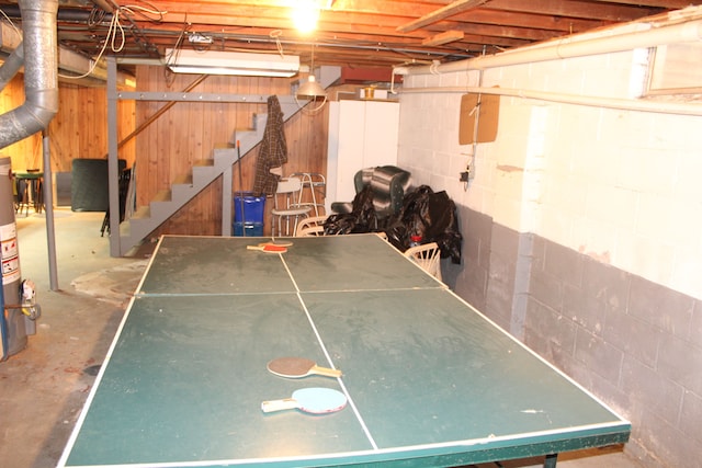 rec room with concrete floors and wood walls