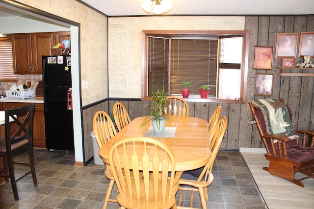 dining room featuring crown molding and wooden walls