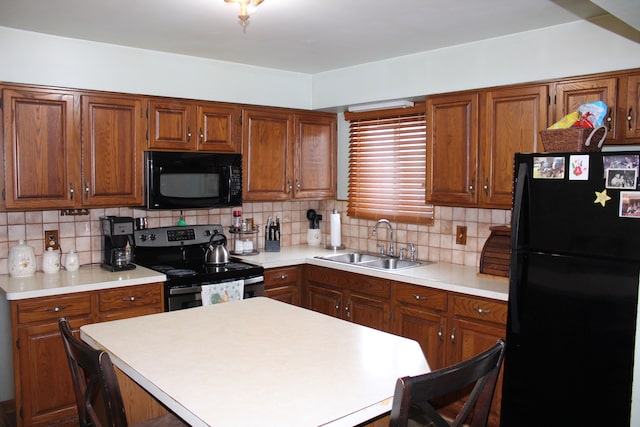 kitchen with sink, decorative backsplash, a breakfast bar, and black appliances