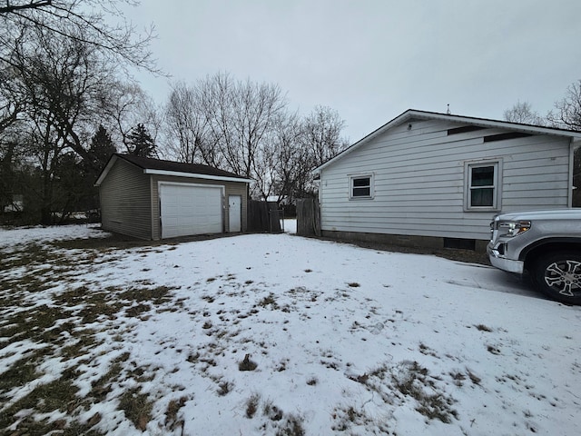 snow covered property with an outbuilding and a garage