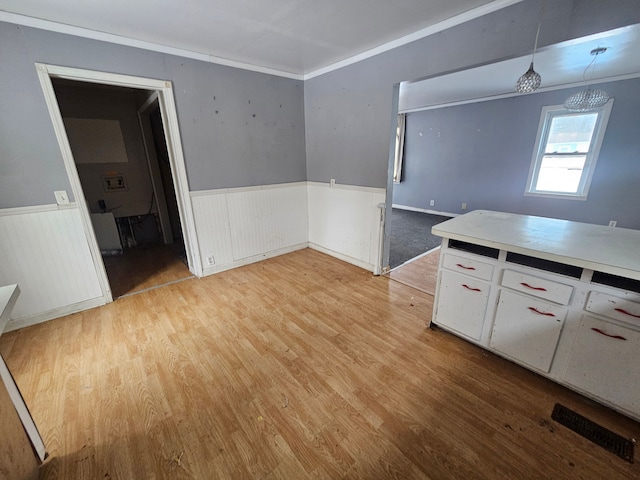 interior space with crown molding and light hardwood / wood-style floors