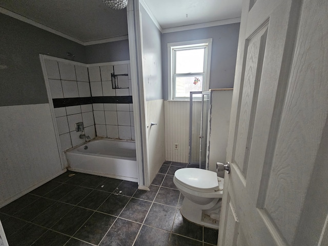 bathroom featuring crown molding, tiled shower / bath, tile patterned floors, and toilet