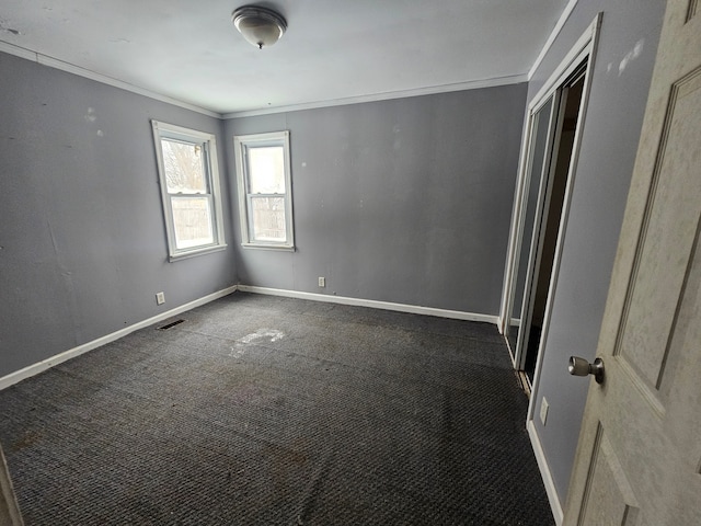 carpeted spare room featuring crown molding