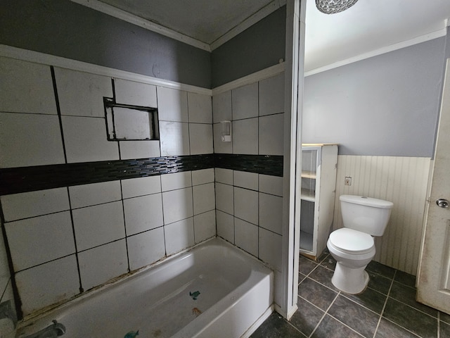 bathroom featuring tile patterned flooring, a bathing tub, crown molding, and toilet