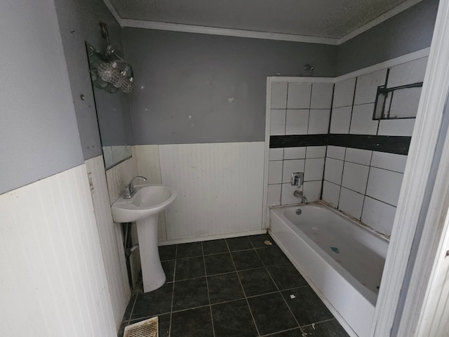 bathroom with a bathing tub, sink, and tile patterned floors